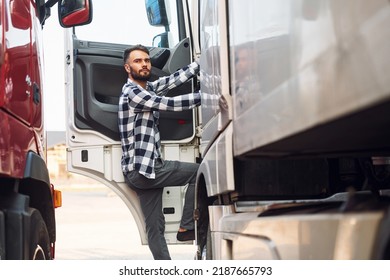 Opening the door. Young truck driver is with his vehicle at daytime.