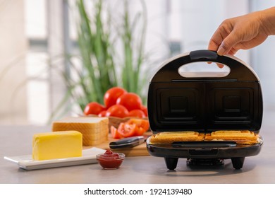 Opening The Lid Of A Sandwich Making Machine