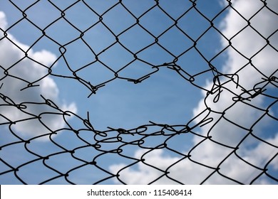 Opening in metallic fence against a blue sky with white clouds. Challenge / uncertainty / breakthrough concept / metaphor. Chain-link, wire netting, wire-mesh, cyclone hurricane fence.

Happy - sad,