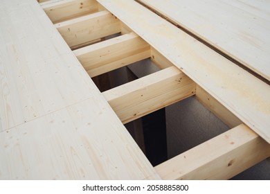 Opening in a new floor on a building site exposing the trusses or wooden beam supports below in a construction concept
