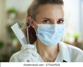 Opening Small Business After Covid-19 Pandemic. Portrait Of Elegant Hair Salon Employee In Apron With Medical Mask, Gloves, Hair Comb And Scissors.