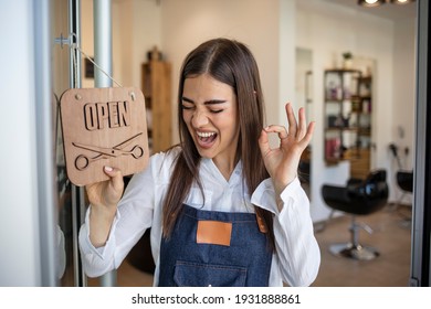 Opening small business after covid-19 pandemic. Closeup on smiling middle aged small business owner woman in apron with crossed fingers showing open sign. - Shutterstock ID 1931888861