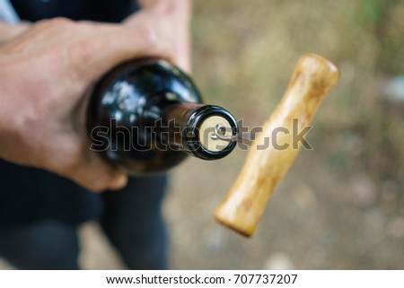 Opening a wine bottle with a corkscrew