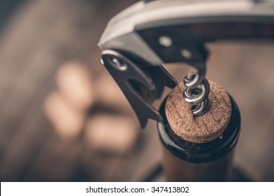Opening a wine bottle with a corkscrew in a restaurant