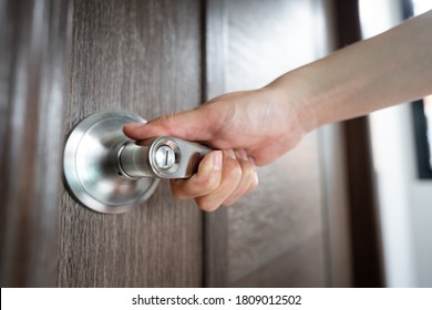 Opening wooden door action, Close-up and selective on people's hand which is pushing on the handle.