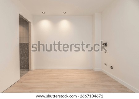 Open-plan room with solid wood flooring, where the sound of footsteps echoes in the silence
