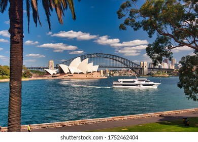 The Opera House And Sydney Bridge Framed By Trees And Viewed Across Farm Cove From Mrs Macquarie's Point, Sydney, New South Wales, Australia.  03-22-2018