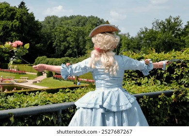 An opera singer performs on stage to a crowd in a well-kept castle park in Arcen, Netherlands