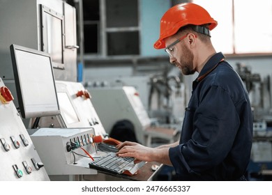 Operating the machine. Factory worker is indoors with hard hat. - Powered by Shutterstock