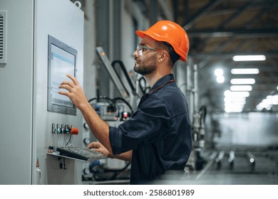 Operating the machine. Man is working in the modern factory.