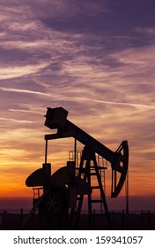 Operating Oil And Gas Well Profiled On Sunset Sky