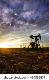 Operating Oil And Gas Well, In Remote Field, Under Warm Evening Light