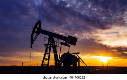 Operating Oil And Gas Well, In Remote Field, Under Warm Evening Light