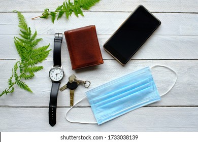 Operating Room Mask, Keys, Watch, Phone And Wallet On Wooden Table