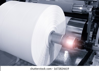 The operation of automatic plastic bag production machine. Close-up of the roller of the polyethylene bag production machine.  machine for packaging with cellophane - Powered by Shutterstock