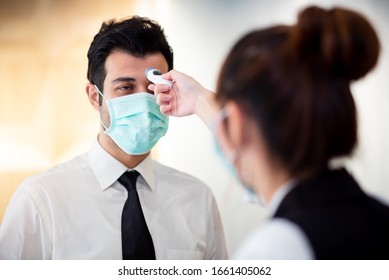Operator Check Fever by Digital Thermometer Visitor at Information Counter for Scan and Protect from Coronavirus (COVID-19) Outbreak - Healthcare Concept - Shutterstock ID 1661405062