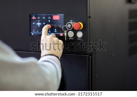 Operator controls modern equipment using a touch control panel. Selective focus.