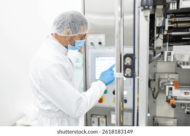 An operator is engaged with a control panel in a cleanroom, highlighting the importance of technology in modern manufacturing practices.