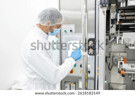An operator is engaged with a control panel in a cleanroom, highlighting the importance of technology in modern manufacturing practices.