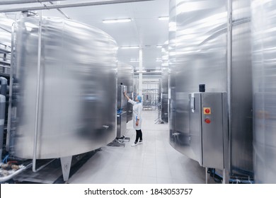 Operator Female In Uniform Uses Control Panel Manage Process Dairy Plant Food Factory Production Line.