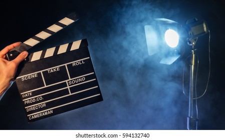 Operator holding clapperboard, studio light with claps on background. Filmmaker background - Shutterstock ID 594132740
