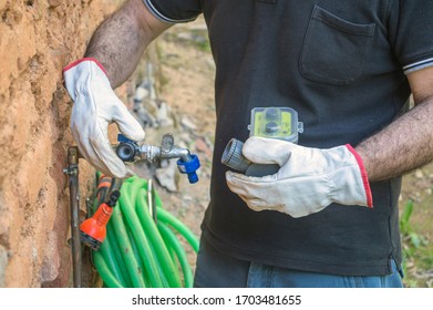 Operator Installing A Water Pressure Regulator On A Tap, Spain, Andalusia