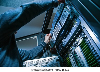 Operator Master repairs computer servers in a server room, close-up
