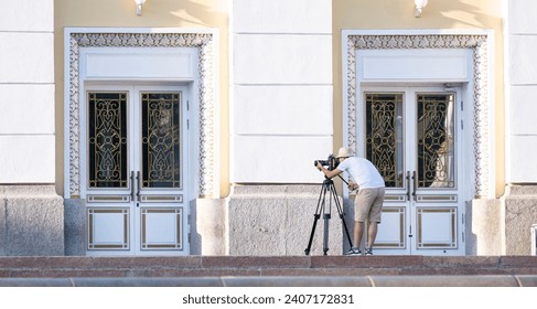 The operator performs video shooting on the street. Reportage photographer, Street photographer. The videographer is on the street.