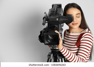 Operator with professional video camera on white background