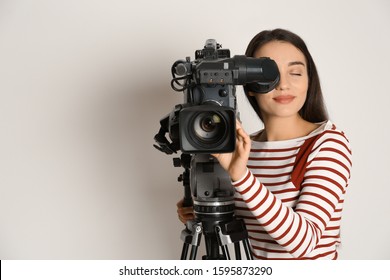 Operator with professional video camera on white background