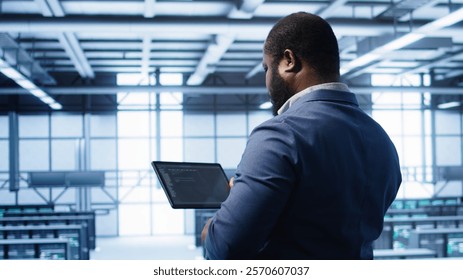 IT operator in server room workspace using tablet to patch network issues affecting transfer rates. Engineer in data center fixing errors affecting server rows rigs, camera B