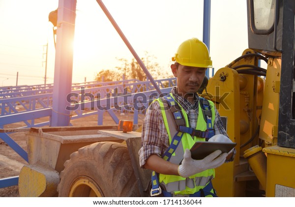 Operator in\
warehouse driving trolley Engineer or architect with white helmet\
driving Loader Truck at construction site,Engineering Construction\
Car Vehicle at the work\
area.