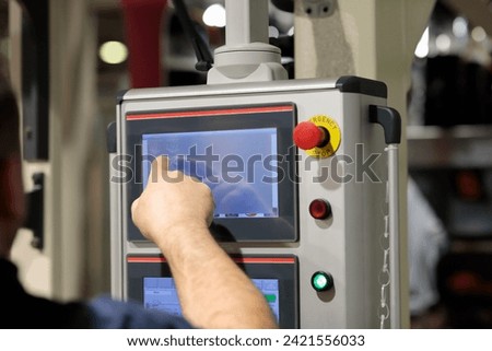 Operator working with touchscreen control panel of industrial machine. Selective focus.