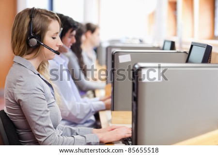 Operators using a computer in call center with the camera focus on the foreground