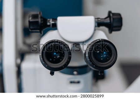 Ophthalmic operating microscope featuring dual eyepieces and precision optics, positioned in a clinical setting, highlighting advanced medical technology and equipment