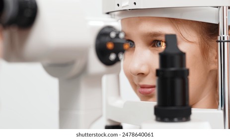 An ophthalmologist does an eye examination, working in a modern clinic with professional equipment. A girl checks a child's eyesight. - Powered by Shutterstock