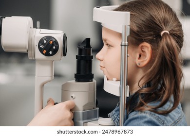 An ophthalmologist does an eye examination, working in a modern clinic with professional equipment. A girl checks a child's eyesight. - Powered by Shutterstock