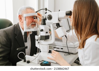 ophthalmologist examination of elderly man with slit lamp. microscope and focused light source. device for high-precision examination of eye to determine condition of lens, cornea. medical equipment.