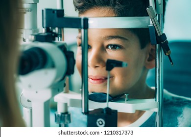 Ophthalmologist examining boy with slit lamp 