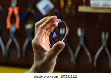 ophthalmologist hands close up, showing a glass lens for spectacles. Blurred background. Ophtalmologist equipment. Vision correction concept.