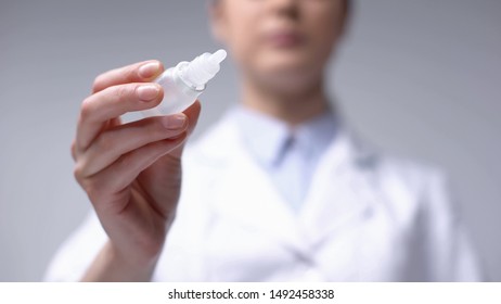 Ophthalmologist holding drops for ocular fundus examination, eyesight checkup - Powered by Shutterstock