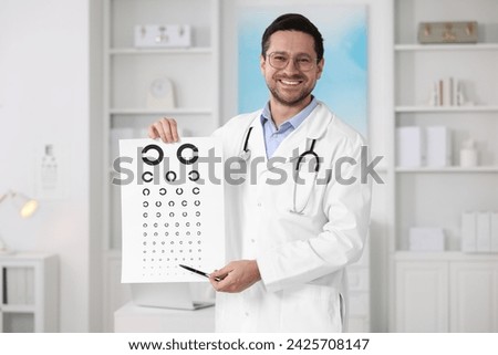 Ophthalmologist pointing at vision test chart in clinic