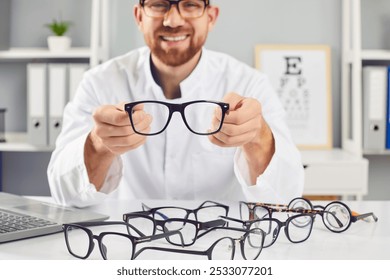 Ophthalmologist showing glasses, smiling doctor in clinic, helping to choose correct medical vision service. Solving optometry problems, eyes testing, prescribing contact lenses in optical store  - Powered by Shutterstock