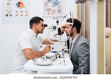 Ophthalmologist using a phoropter while conducting an eyesight medical checkup on a male patient in a well-equipped ophthalmology clinic, ensuring thorough eye care and accurate diagnosis
