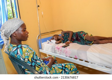 Opialu, Benue State - March 6, 2021: African Parent Caring For Sick Child In A Rural Clinic