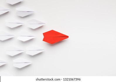 Opinion leadership concept. Red paper plane leading another ones, influencing the crowd, white background, top view with free space