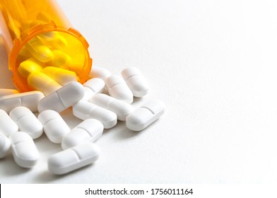 Opioid epidemic, drug abuse and overdose concept with scattered prescription opioids spilling from orange bottle with copy space. Hydrocodone is the generic name for a range of opiate painkillers