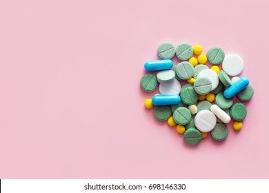 Opioid Pills. Opioid epidemic and drug abuse concept. Different tablets, pills, capsule on a pink background.  Heap mix therapy drugs. Copy space