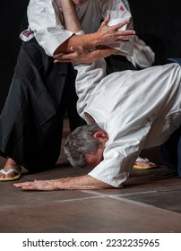 Opponent  knockdown and immobilization. Black belt aikido master during a training session. 