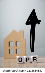 OPR Or Overnight Policy Rate Character Increase On A White Cube With An Arrow And House Replica Over Grey Background